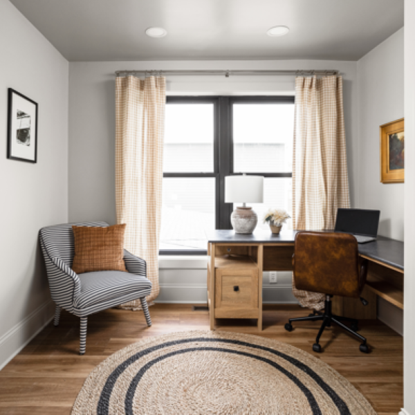 a gray office with a desk in front of a window and luxury vinyl plank flooring